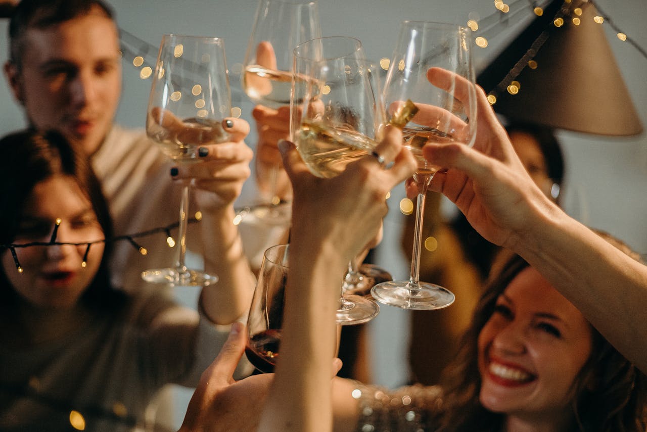 A group of friends joyfully toasting with champagne glasses at a festive celebration.
